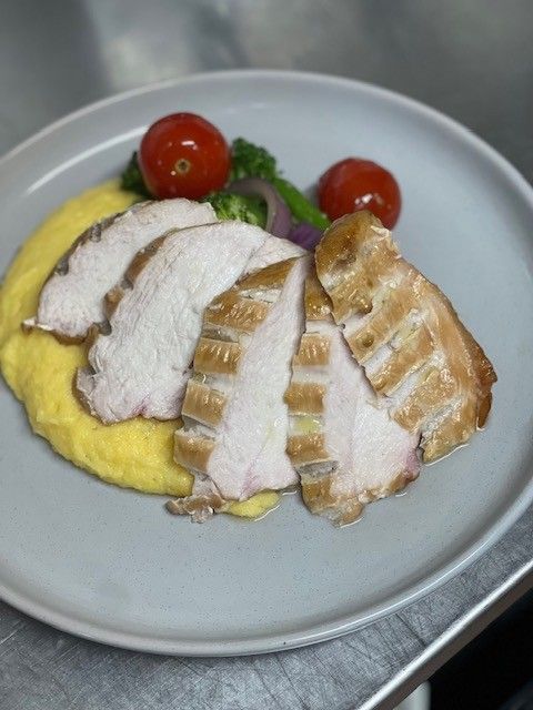 Smoked chicken breast over polenta with vegetables